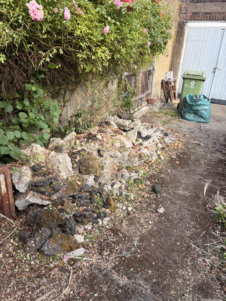 Garden path with broken concrete and rubble before collection