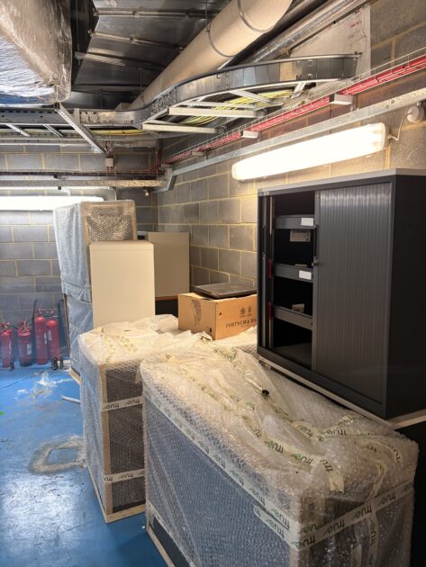 Metal office storage cupboards in the basement before collection