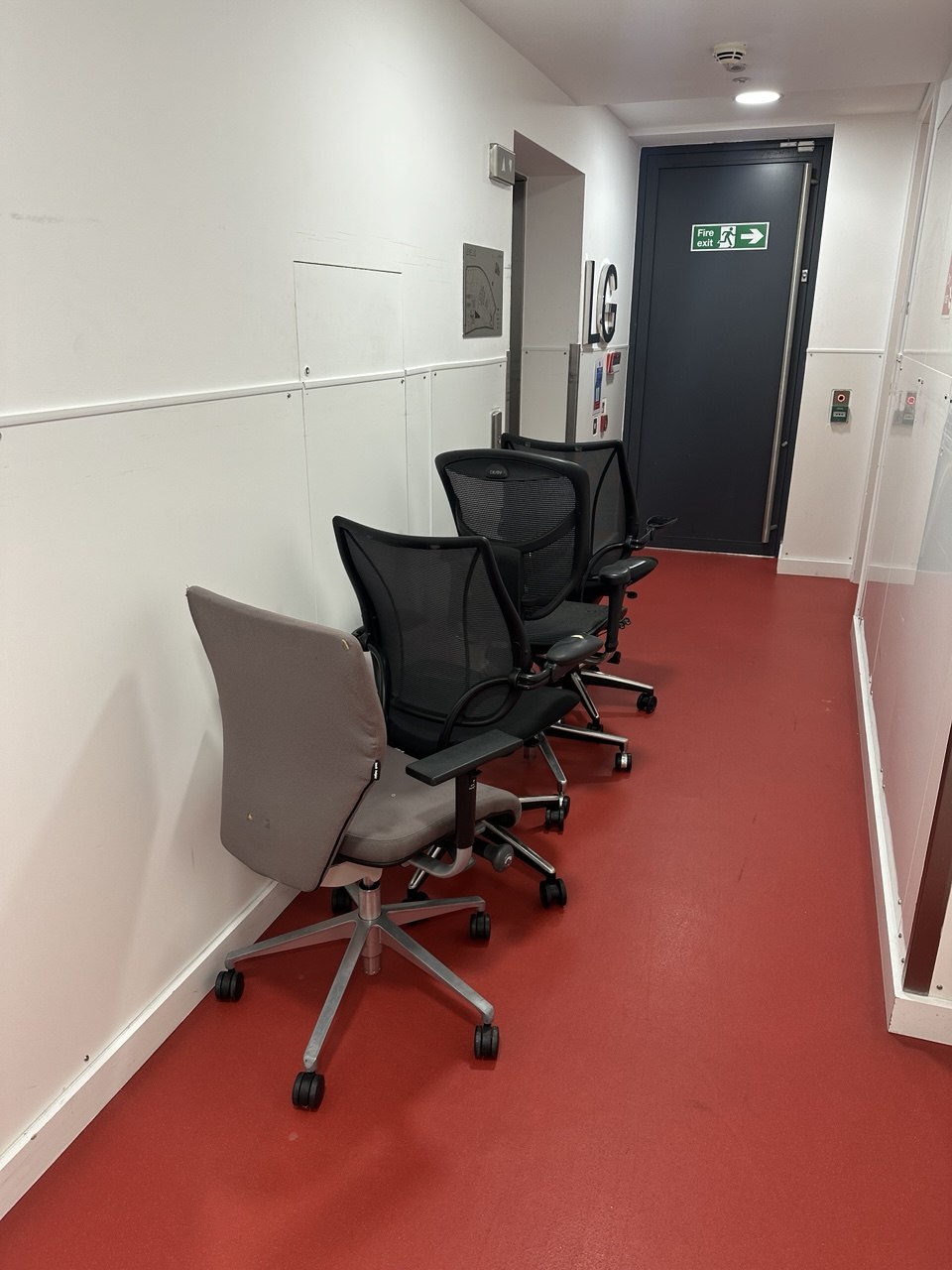 Office chairs staged in a commercial building corridor for clearance